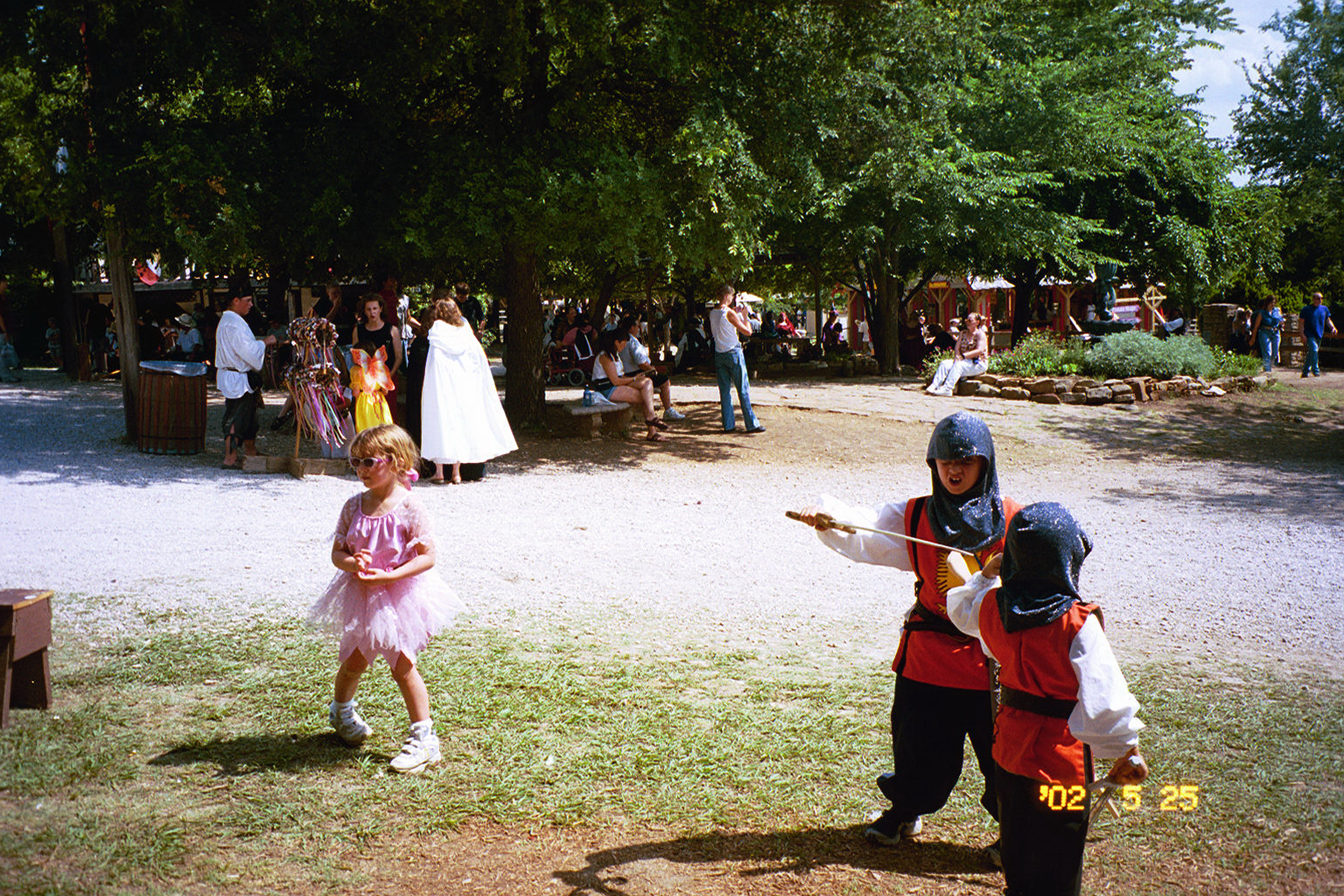 Jacob and David sword fighting while Sara VanNewkirk is ignoring them